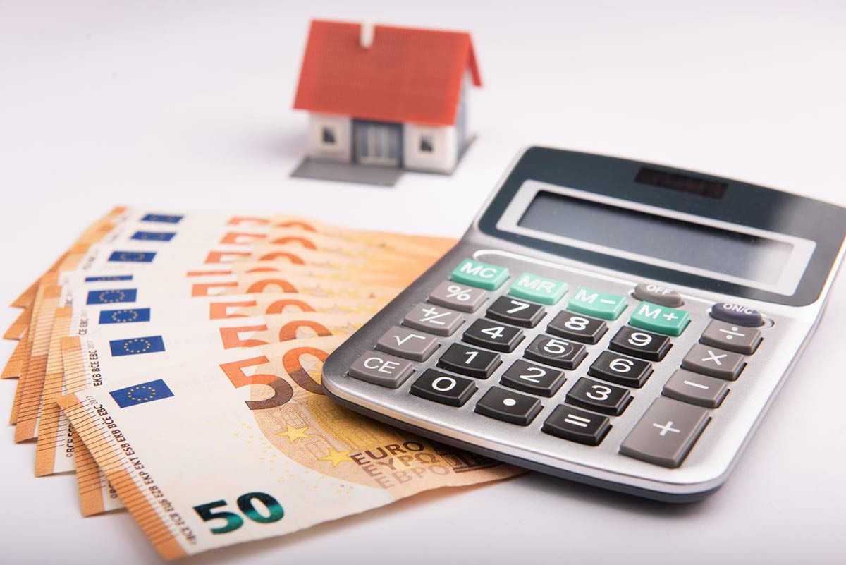 Symbolbild Annuitätendarlehen - Haus mit Taschenrechner und Geld