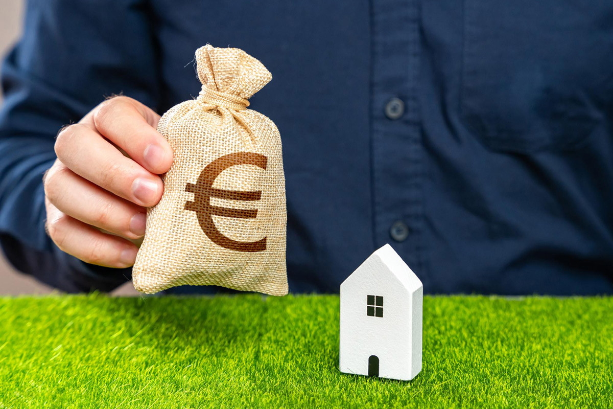 Hypothekarkredit Symbolbild: Mann mit Geldsack und Haus