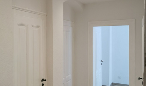 Charming renovated two-room apartment in a historic building, featuring a fitted kitchen, a bright bathroom, and a bathtub.