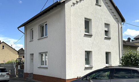 Einfamilienhaus mit Pool, Garten und Carport.