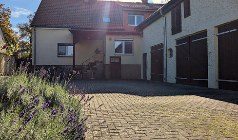 Idyllic three-sided courtyard with large garden