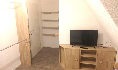 A small, furnished room in a shared apartment.