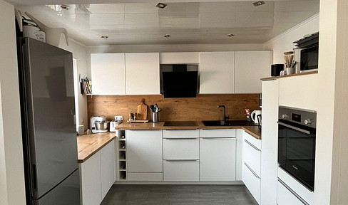 Refurbished 3-room apartment with fitted kitchen, fireplace & parking space