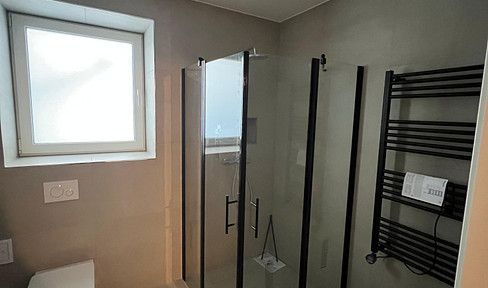 Brand new: Modern 2-room apartment with KfW40 funding, featuring a fitted kitchen and parking space, perfect for singles or couples.