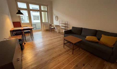 Beautiful, centrally located apartment in a historic building, featuring a balcony, wooden floors, and high ceilings.