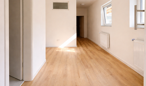 Modern, renovated 2-room apartment with an open-plan, built-in kitchen area, including electricity and heating costs.