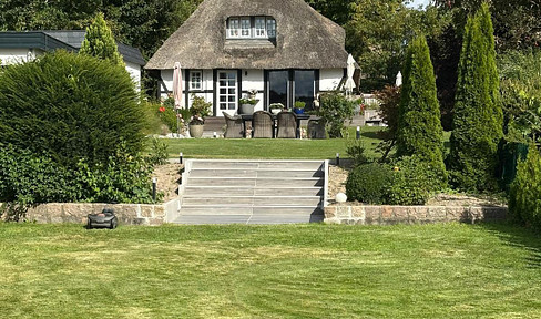 Thatched half-timbered farmhouse with a boat landing.