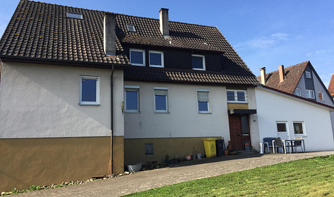 Detached two-family house with garages and an undeveloped building plot.