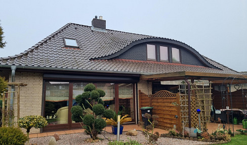 Bungalow with a hipped roof and an attached apartment.