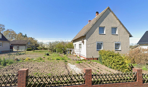 Detached house in a quiet village location, with a large plot of land, garage, and stables.