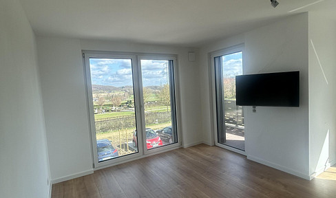 First occupancy in Osnabrück-Voxtrup: High-quality, partially furnished 2.5-room apartment with a balcony overlooking greenery.
