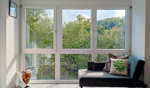 Stylish 2.5-room designer apartment with a conservatory, fully furnished, including a parking space in an underground garage, and with views of greenery.