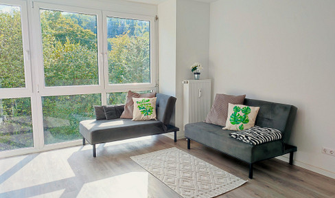 Stylish 2.5-room designer apartment with a conservatory, fully furnished, including a parking space in an underground garage, and with views of greenery.