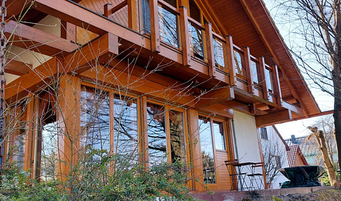 A unique wooden house in a green setting, located on the outskirts yet still centrally located.
