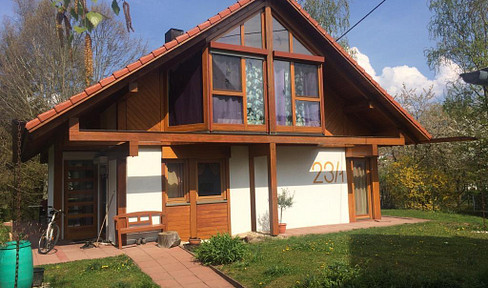 A unique wooden house in a green setting, located on the outskirts yet still centrally located.