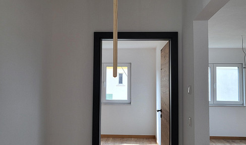 Erstbezug: Helle 2‑Zi‑DG‑Wohnung mit Carport und E‑Ladestation