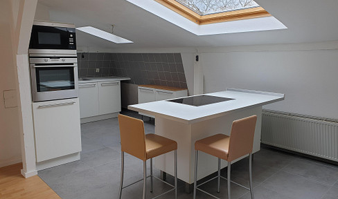 Bright 3.5-room attic apartment with a kitchen island and access to a garden.