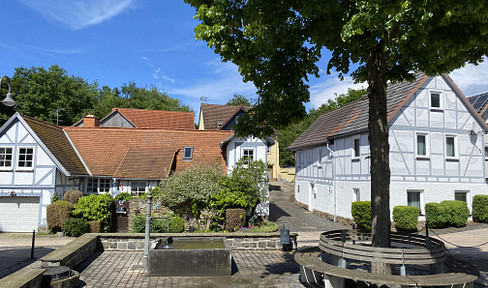 Charming courtyard property with 3 residential units, garages, a barn, and a hillside garden.