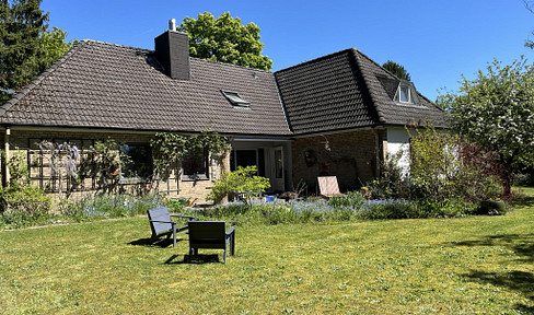 House situated on a secluded property with mature trees.