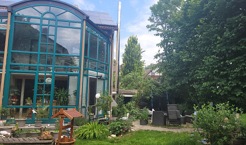 Detached house with an attached apartment and conservatory.