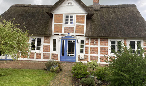 Partially renovated, listed thatched-roof house.