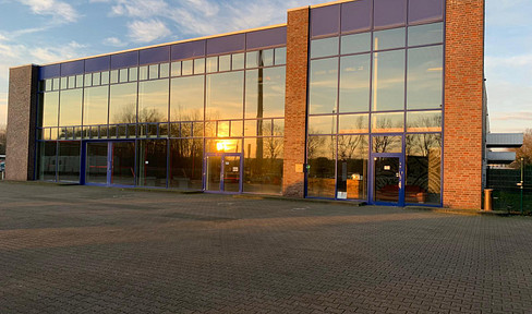 Bright commercial hall with a large glass facade and office space – suitable for a variety of uses.