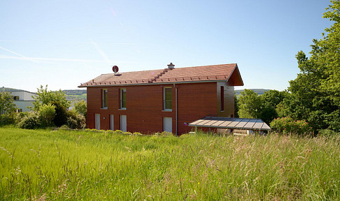Detached single-family house in a unique location on the edge of a field, featuring spacious terrace areas.