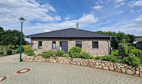 Modern bungalow with a view of the fields, located near the Baltic Sea, built to KFW55 standards, featuring a heat pump and a fitted kitchen.
