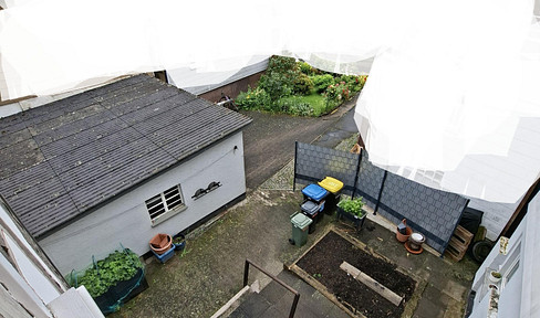 Charming half-timbered house with an inner courtyard, two garages, and great potential.