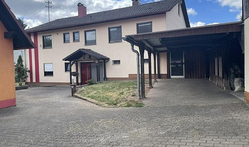 Property with a single-family house, including a separate living unit (ELW) and a second residential building, garages, carport, barn, and workshop.