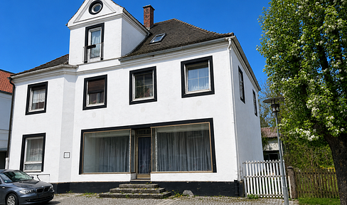 Central residential and commercial building with a commercial hall and a photovoltaic system.