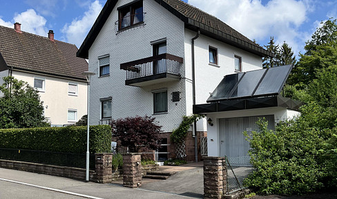 Detached two-family house with a garage and a beautiful garden.