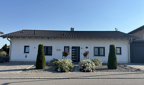 Bungalow with solar panels and a swimming pool.