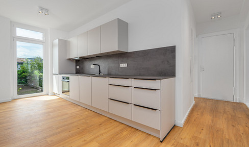 Completely renovated 2-room apartment in a historic building in Berlin-Köpenick: Available for first occupancy, featuring a living room with an open-plan kitchen, a bathroom with natural light, and a balcony.