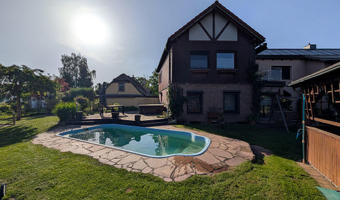 Residential paradise with multi-generational living, solar PV and thermal energy systems, 80 kWh battery storage, 2 carports, swimming pool, and space for a camper van.