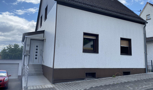 Detached house with a balcony and garage.