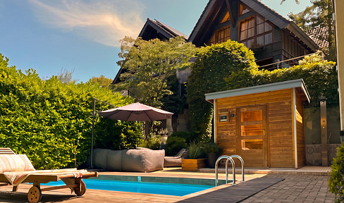 Architecture meets privacy – a unique single-family home with a pool, sauna, and garden, nestled in a green setting.