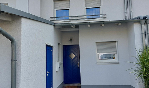 Well-maintained terraced house with a green roof.