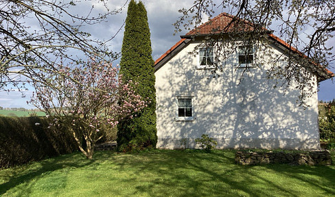 Detached family home in a country house style: spacious plot at the edge of a field, double garage, and carport.