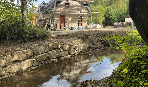 Odenthal has renovated their house by the stream, which sits on a 1750 square meter plot of land, and includes a heat pump and solar panels, meeting the KfW 55 energy efficiency standard.