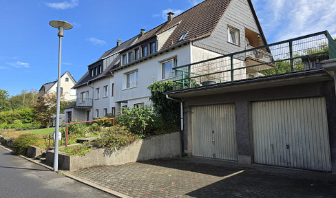 Versatile two-family house with a double garage and a large plot of land.
