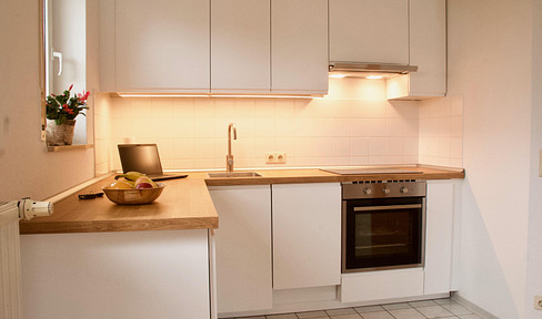 Ground-floor 1-bedroom apartment with a terrace - modern fitted kitchen and shower enclosure.