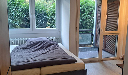 Fully furnished one-bedroom apartment with a balcony and a view of the greenery.