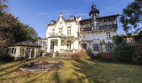 Historic villa with a view of the Rhine, including an outbuilding and garage.