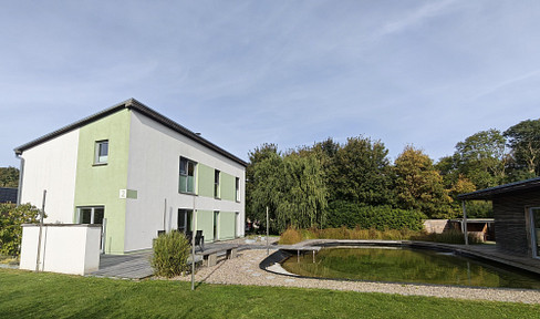 Architect-designed house with a natural pond, sauna, solar panels, and a versatile outbuilding.