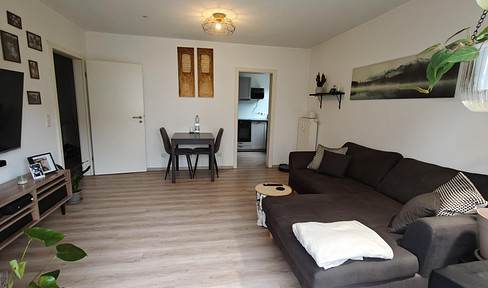 Ground-floor 2-room apartment with balcony and parking space.
