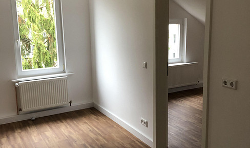 High-quality renovated apartment in a historic building, featuring a fitted kitchen and a bathroom with natural light.