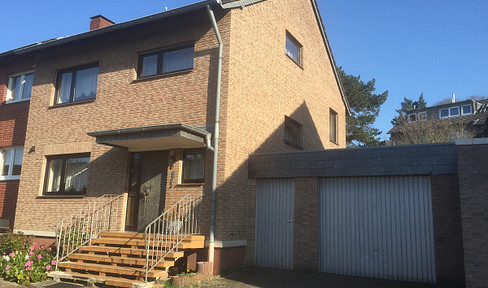 Detached house with a single-sided extension, featuring a basement garage.