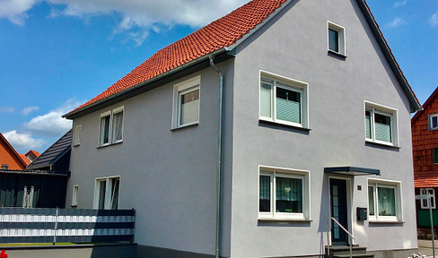 Detached single-family house with garden, double garage, and carport.
