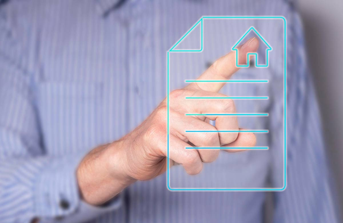 Symbolbild Immobilienstrategien: Mann klickt Haus auf Dokument auf Display an